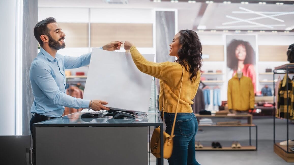 Shopper receiving a bag at a retail counter