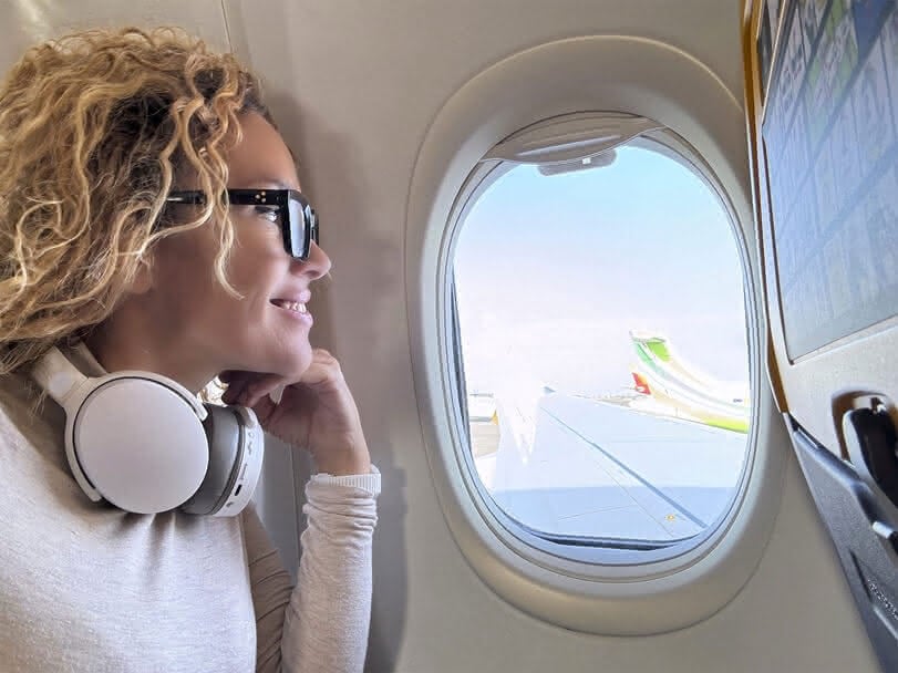 Passenger smiling out of an airplane window