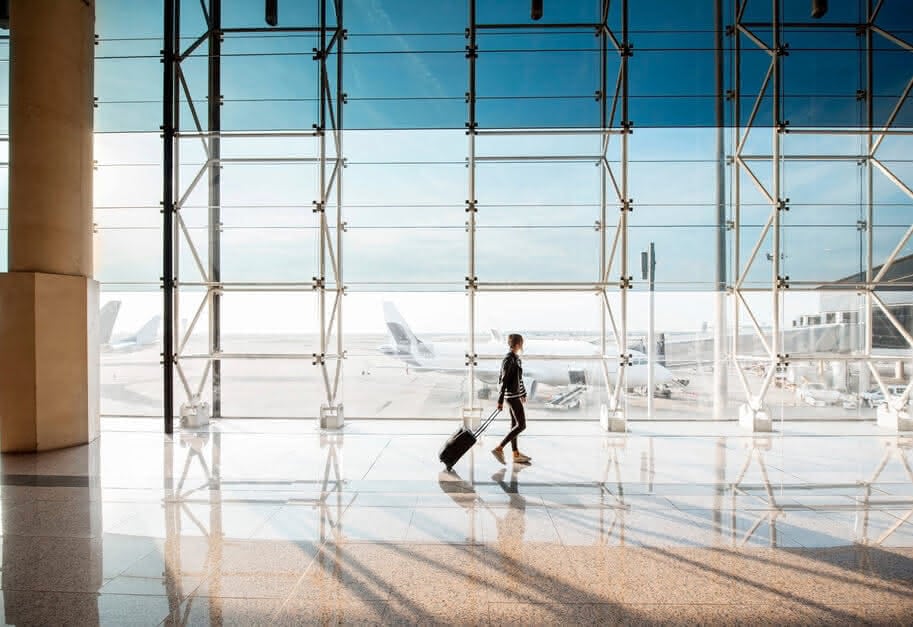 Traveler walking through a sunlit airport terminal